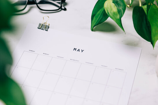 Printed May Calendar Behind Greenery