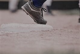 Close-up of Little league baseball player ready to run from third base.