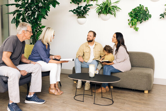 Young Family Reading the Bible with an Older Couple