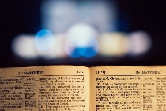 Bible Open to the Book of Matthew with Stage Lights Behind