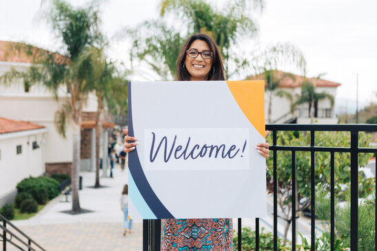 Volunteer Holding a Welcome Sign