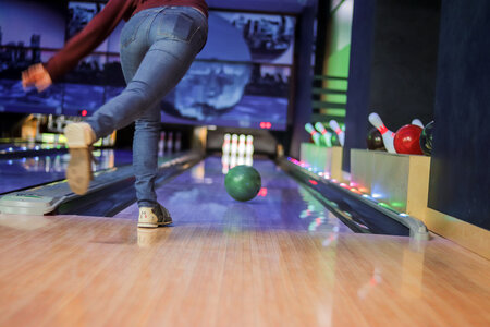 Woman in club for bowling is throwing ball