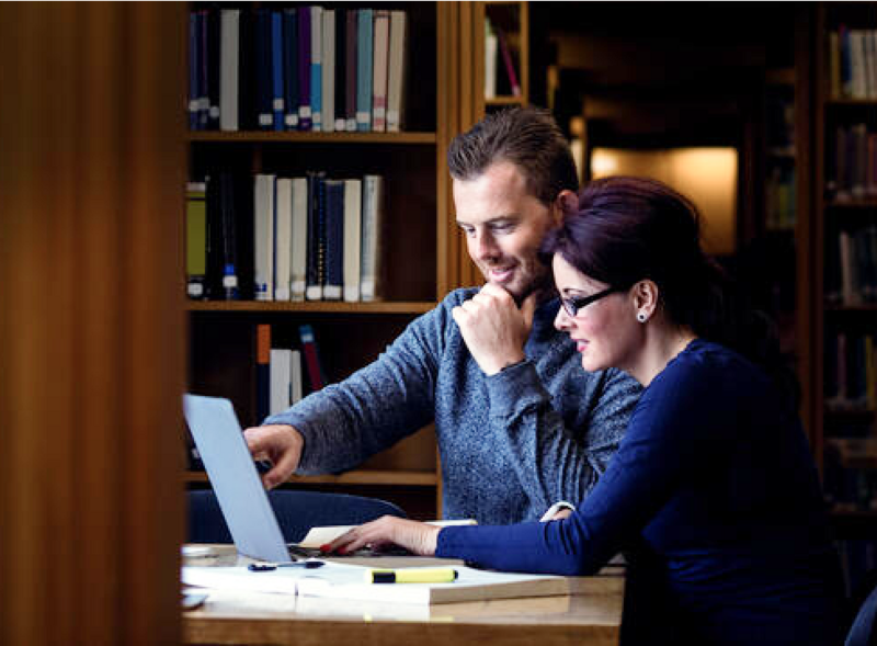 Man pointing at Woman's laptop screen