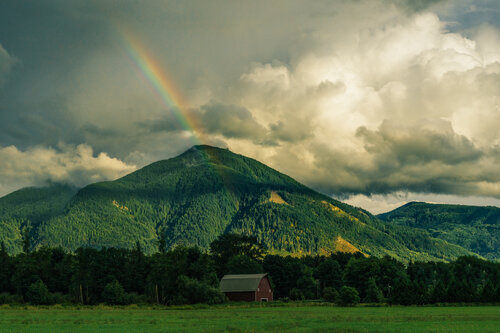 A rainbow over a green mountain