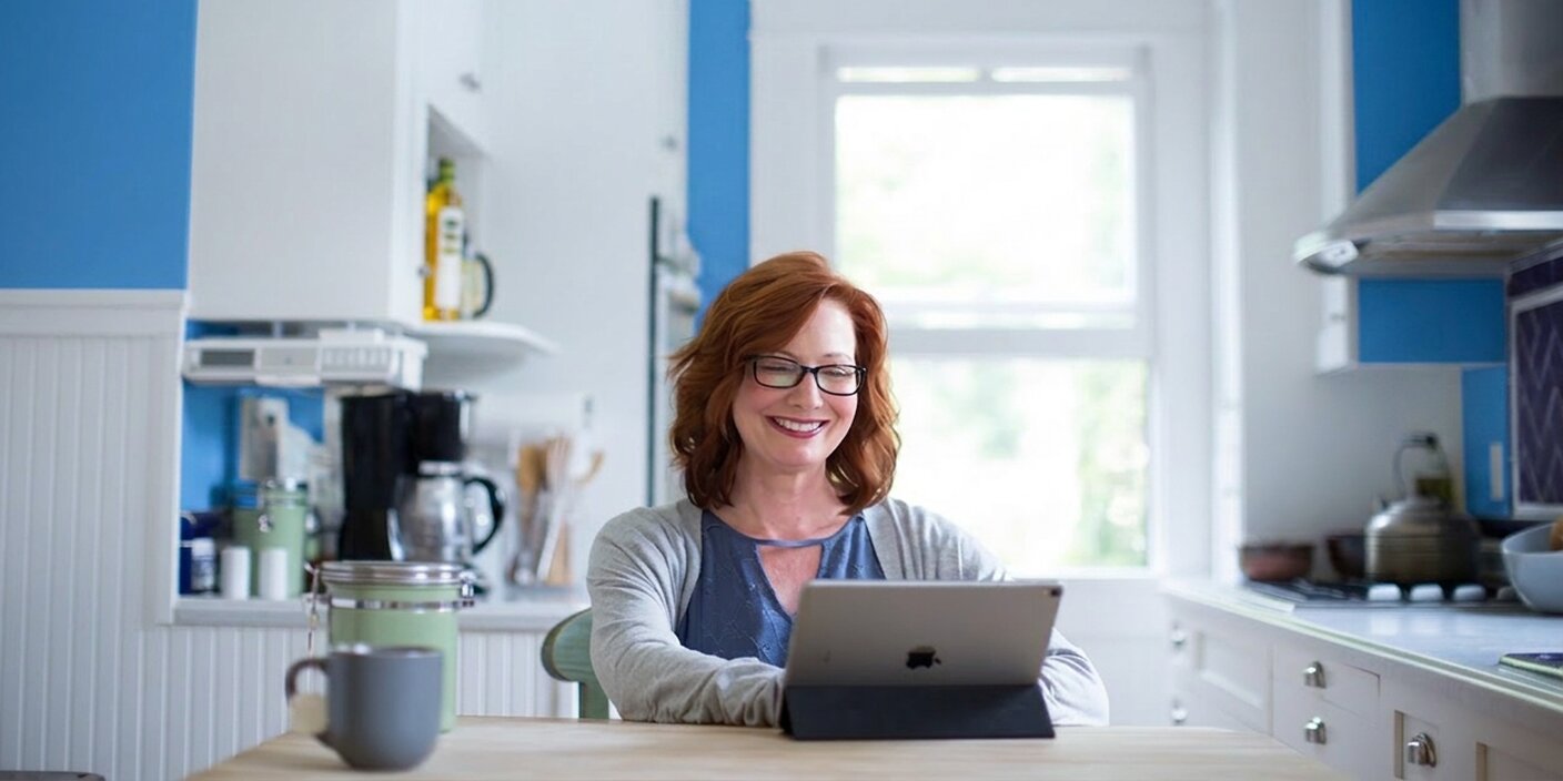 woman watching Logos Mobile Ed on her laptop in the kitchen