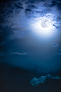 Attractive photo of background nighttime sky with clouds and bright full moon with shiny. Nightly sky with beautiful full moon. Outdoors at night. The moon were NOT furnished by NASA.