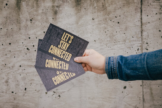 Hand Holding "Let's Stay Connected" Cards