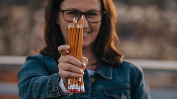 Woman Holding out Pencils