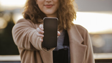 Woman Holding Out a Smart Phone