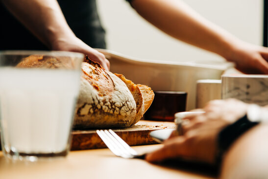 Hand Grabbing a Piece of Bread