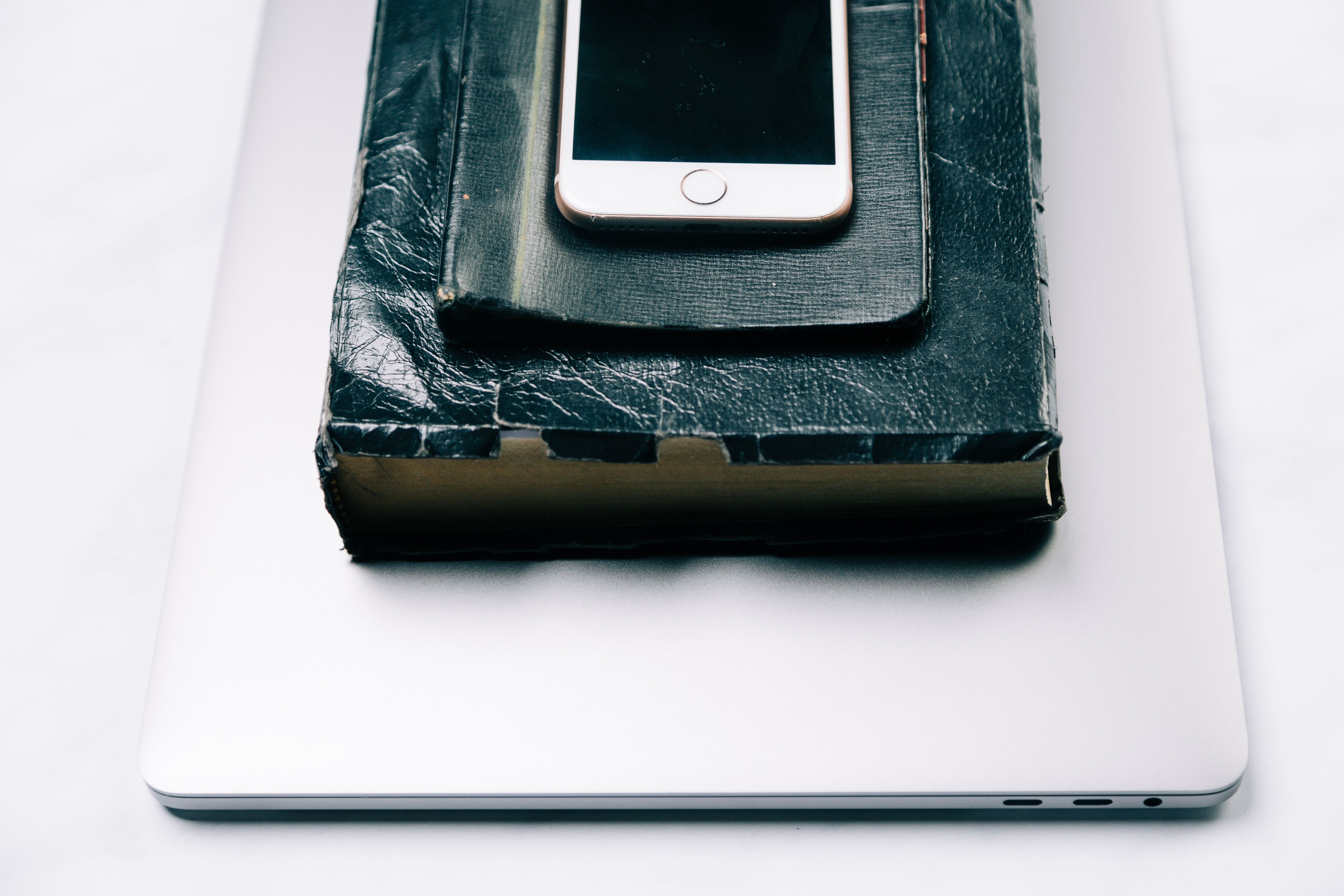 Laptop, Bible, and Phone stacked