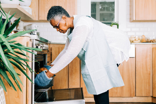 Woman Pulling Thanksgiving Turkey out of the Oven