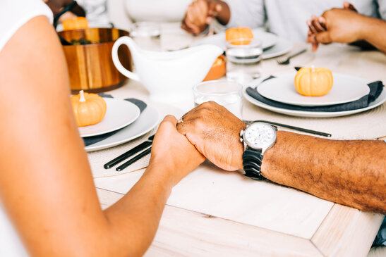 Holding Hands in Prayer at Thanksgiving Table