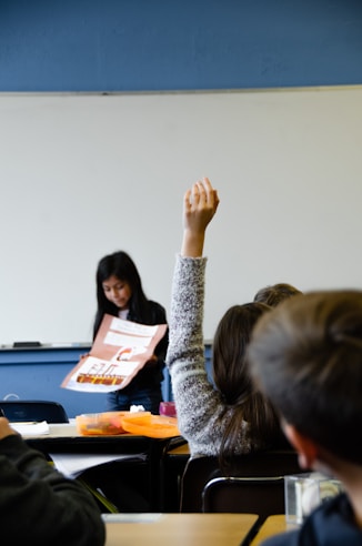 Girl raises her hand in class
