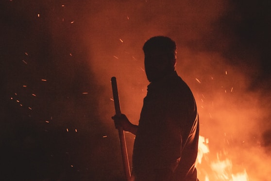 Silhouette of a man standing in front of fire and holding a stick, while burning paricles are flying and space.
نمای ضدنور (سایه‌نما، سیلوئت) از یک مرد که جلوی آتش ایستاده و چوبدستی را گرفته، همزمان ذرات گداخته‌ی آتش در فضا پرواز می‌کنند