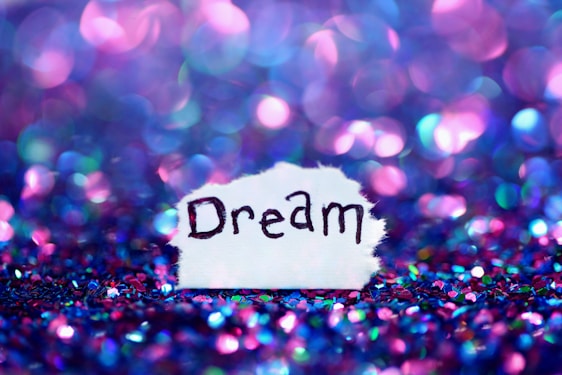 A simple message to dream with shimmery purple and pink glitter bokeh.