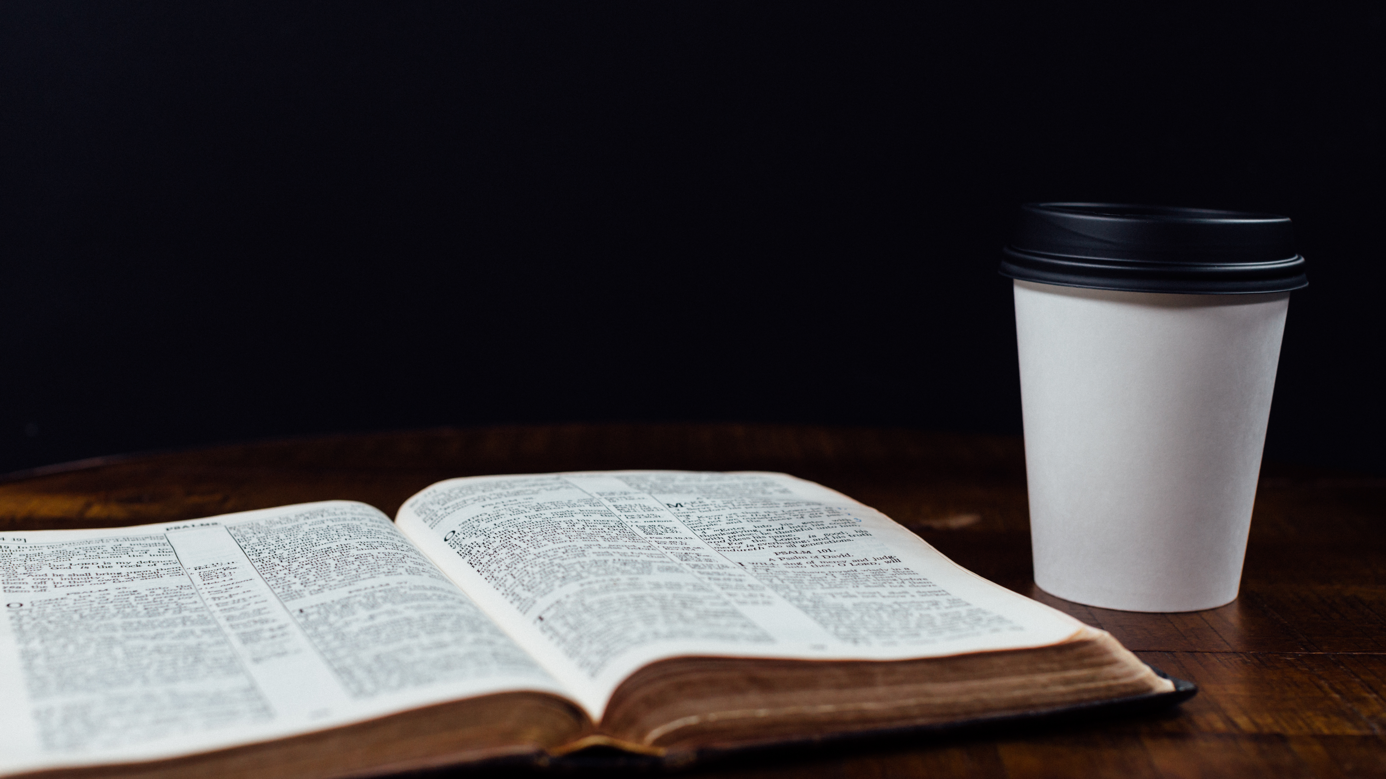 Coffee in to-go cup with open bible