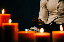 Man Writing in Notebook in Candle Lit Room  image 6