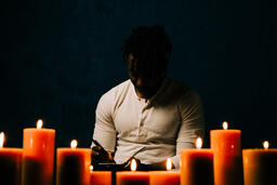 Man Reading Bible in Candle Lit Room  image 25