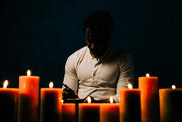 Man Reading Bible in Candle Lit Room  image 8
