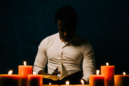 Man Reading Bible in Candle Lit Room  image 26