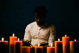 Man Reading Bible in Candle Lit Room  image 27