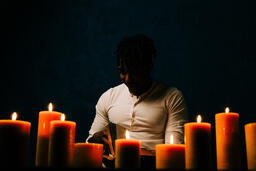 Man Reading Bible in Candle Lit Room  image 9