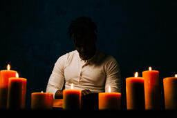 Man Reading Bible in Candle Lit Room  image 13
