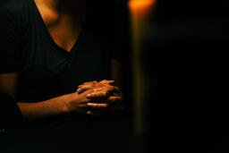 Woman Praying in Candle Lit Room  image 2
