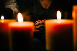 Woman Praying in Candle Lit Room  image 1