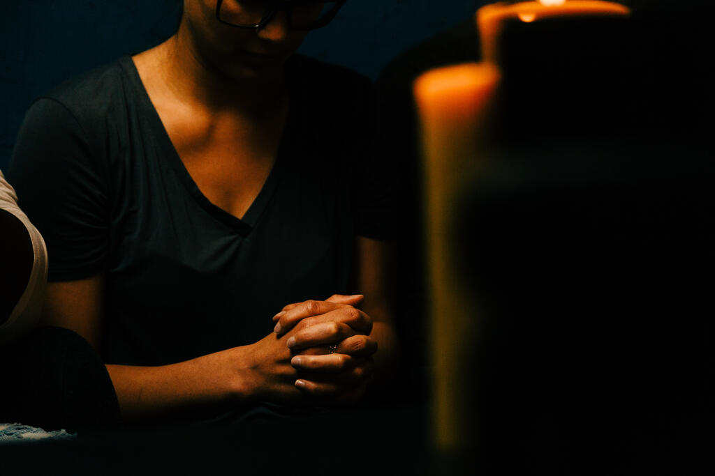 Woman Praying in Candle Lit Room large preview