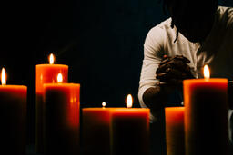 Man Praying in Candle Lit Room  image 3