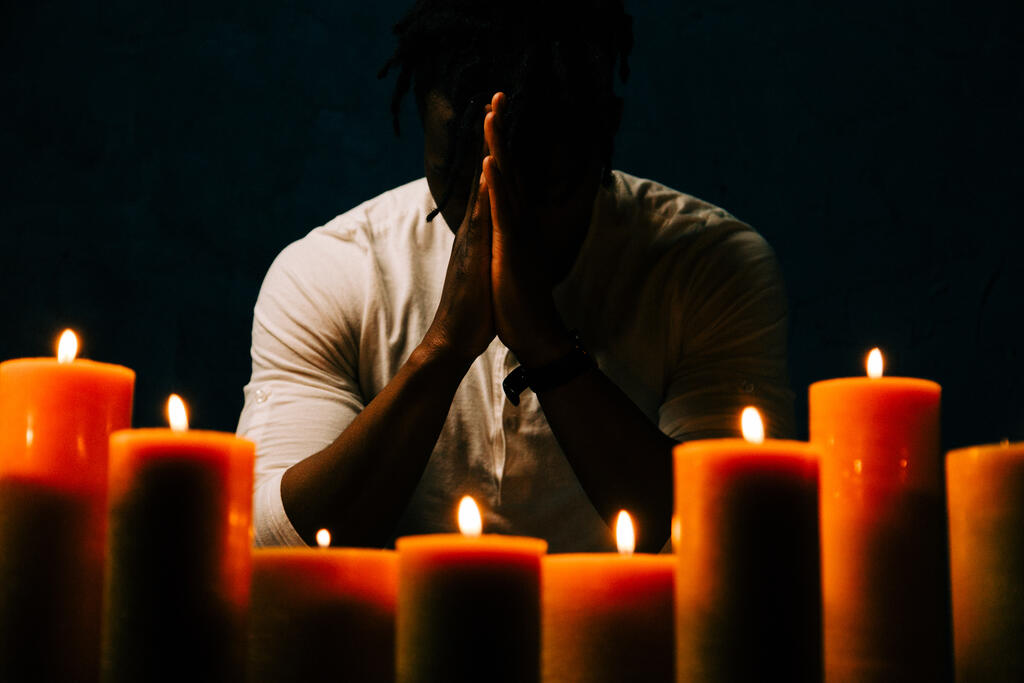 Man Praying in Candle Lit Room - Church stock photos