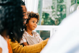 Child Seated on Father's Lap During Thanksgiving Dinner  image 3
