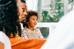 Child Seated on Father's Lap During Thanksgiving Dinner  image 2