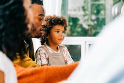 Child Seated on Father's Lap During Thanksgiving Dinner  image 4