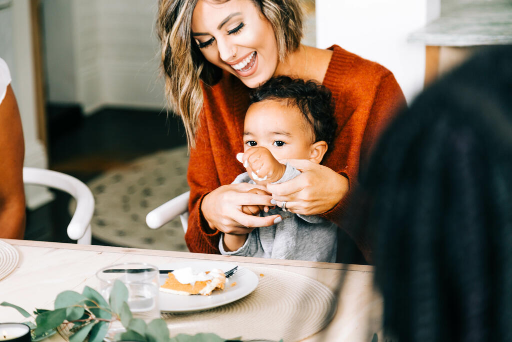Woman Laughing at Thanksgiving Table, Holding Baby large preview