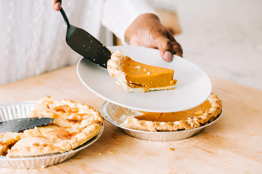 Woman Serving Up Slice of Pumpkin Pie large preview
