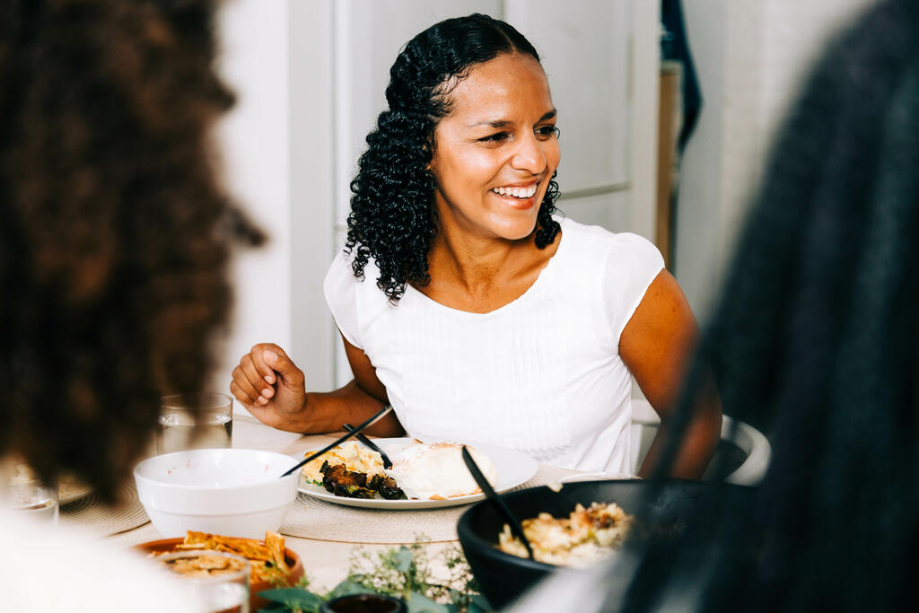 Woman Laughing and Enjoying Thanksgiving Dinner large preview