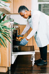 Woman Pulling Thanksgiving Turkey Out of the Oven  image 3