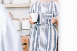 Woman Holding Cup of Coffee and having Conversation in the Kitchen  image 1