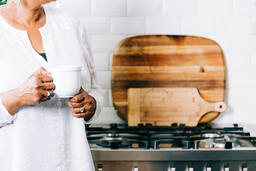 Woman Holding Cup of Coffee in the Kitchen  image 1