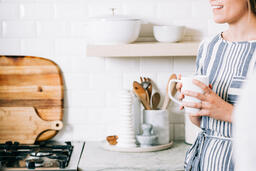 Woman Holding Cup of Coffee and having Conversation in the Kitchen  image 1