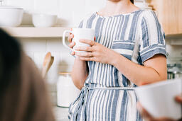 Woman Holding Cup of Coffee and having Conversation in the Kitchen  image 2
