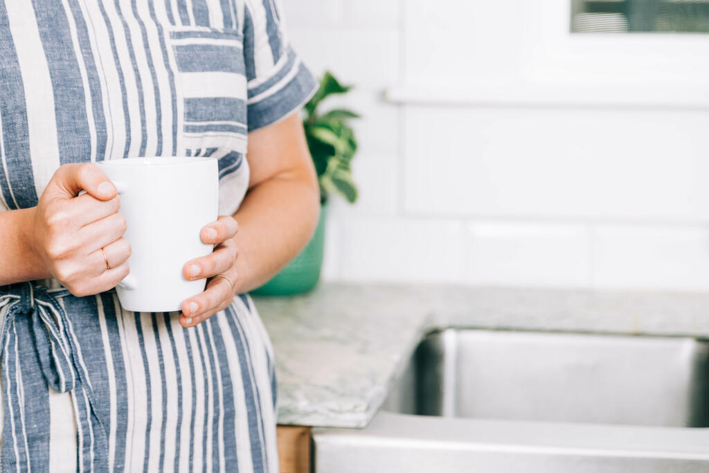 Woman Holding Cup of Coffee in the Kitchen large preview