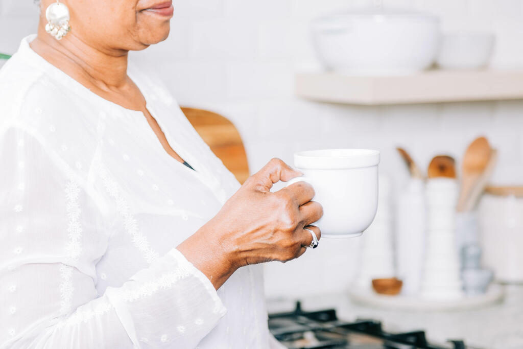 Woman Holding Cup of Coffee in the Kitchen large preview