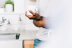 Man Holding Cup of Coffee in Kitchen  image 1