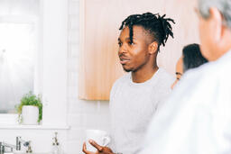 Man Holding Cup of Coffee and Having Conversation in the Kitchen  image 2