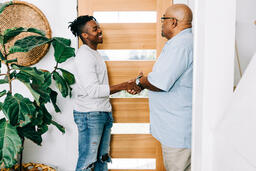 Men Shaking Hands at Entrance of Home  image 1