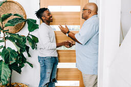 Men Shaking Hands at Entrance of Home  image 2